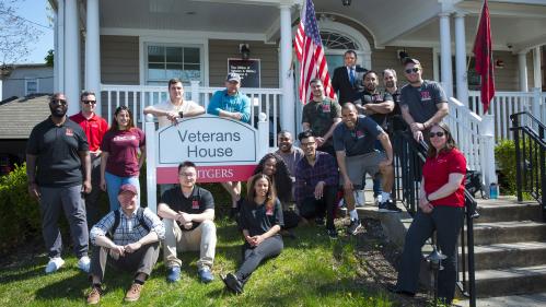 A group of students sit in front of Veterans House