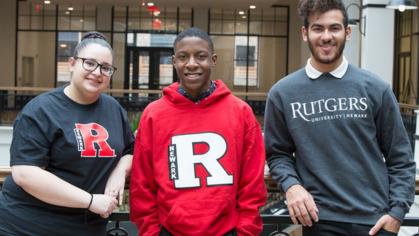 three smiling students wearing Rutgers shirts