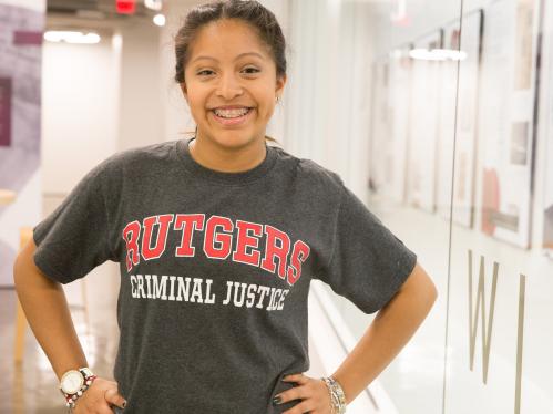 smiling student wears Rutgers Criminal Justice t-shirt